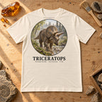 Triceratops t-shirt flat lay – natural PaleoThreads paleo art tee on a fossil prep bench with amber
