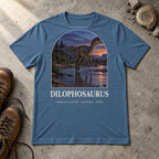 Dilophosaurus t-shirt flat lay – steel blue PaleoThreads paleo art tee with hiking boots and an ammonite