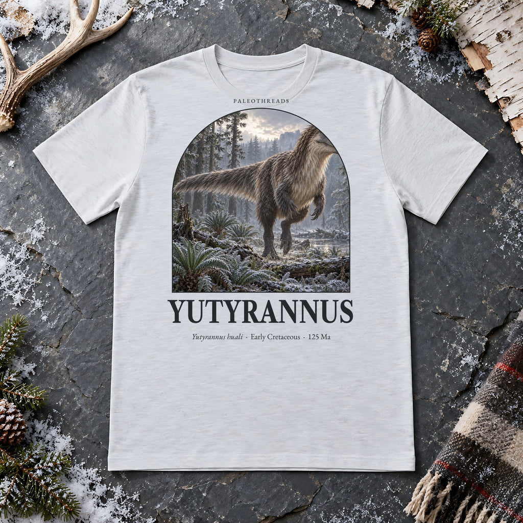 Yutyrannus t-shirt flat lay – ash PaleoThreads paleo art tee on frosty slate with an antler