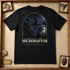 Microraptor t-shirt flat lay – black PaleoThreads paleo art tee in a museum fossil drawer