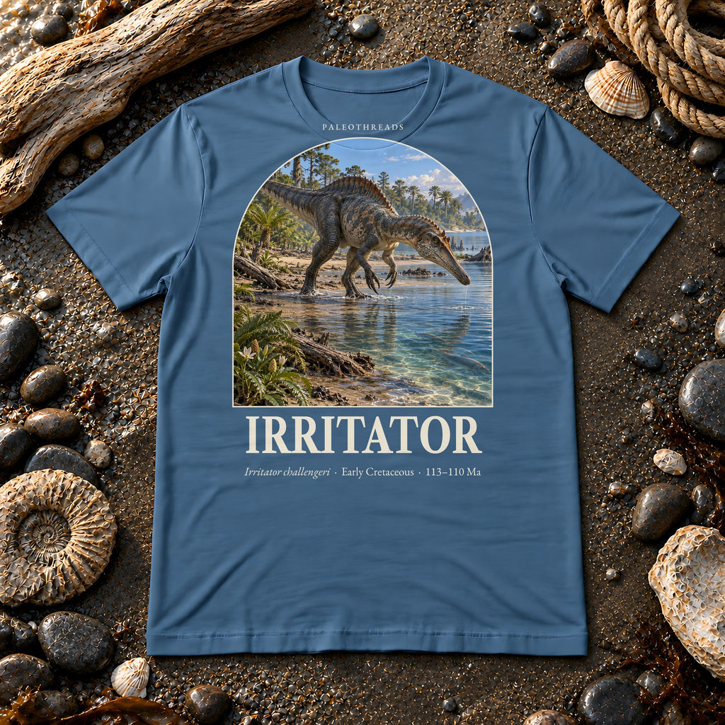 Irritator t-shirt flat lay – steel blue PaleoThreads paleo art tee on a fossil beach with driftwood