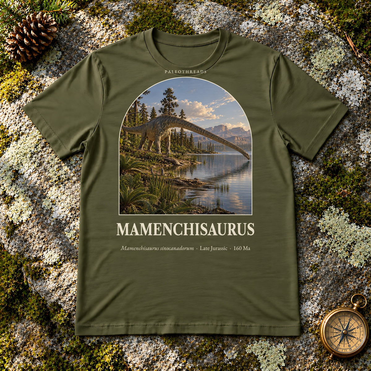 Mamenchisaurus t-shirt flat lay – olive PaleoThreads paleo art tee on mossy rock with a brass compass