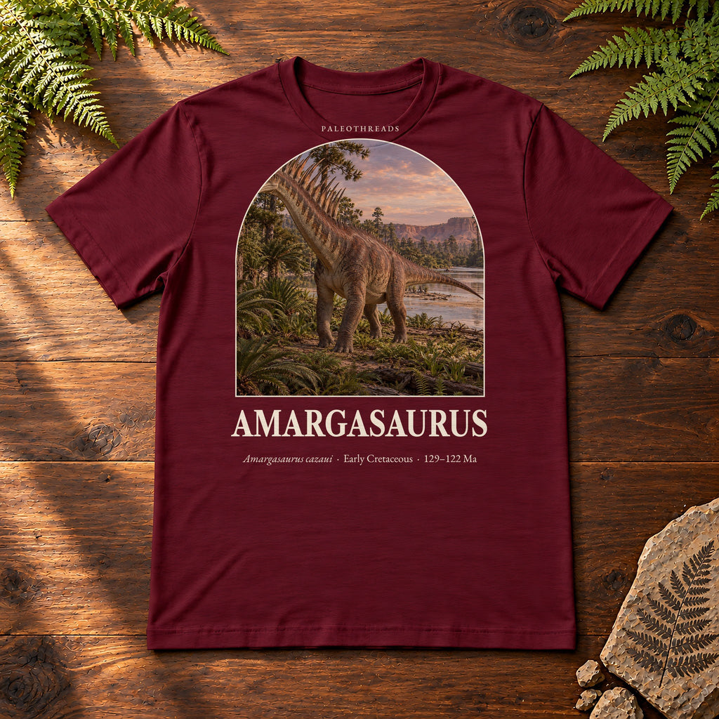 Amargasaurus t-shirt flat lay – maroon PaleoThreads paleo art tee on a walnut field desk with ferns