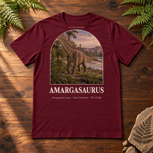 Amargasaurus t-shirt flat lay – maroon PaleoThreads paleo art tee on a walnut field desk with ferns