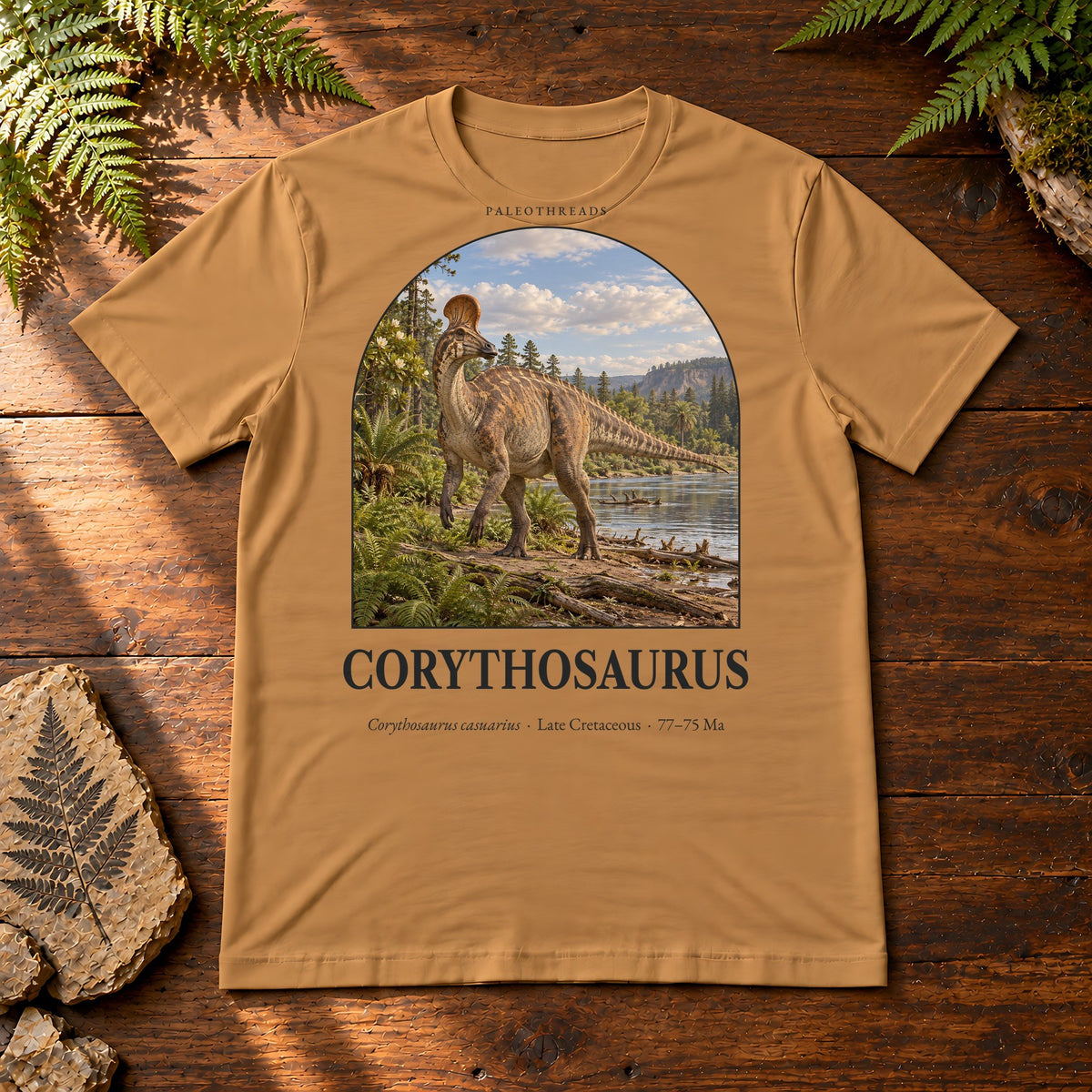 Corythosaurus t-shirt flat lay – toast PaleoThreads paleo art tee on a walnut field desk with ferns
