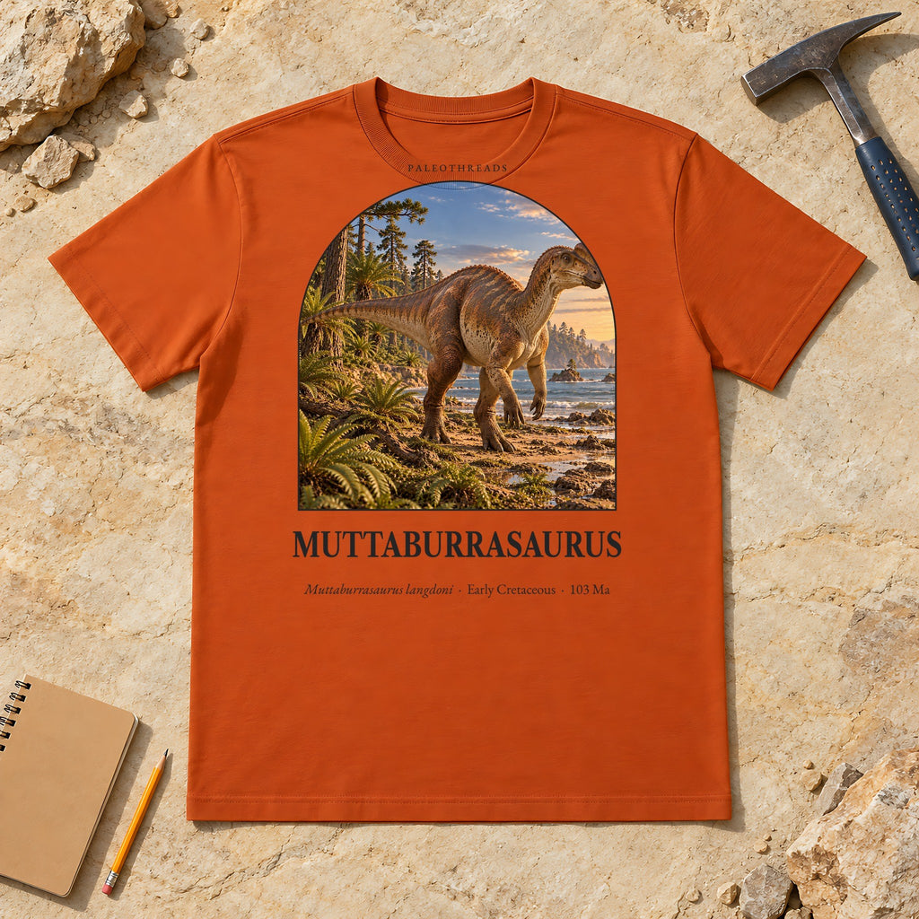 Muttaburrasaurus t-shirt flat lay – autumn PaleoThreads paleo art tee on sandstone with a rock hammer
