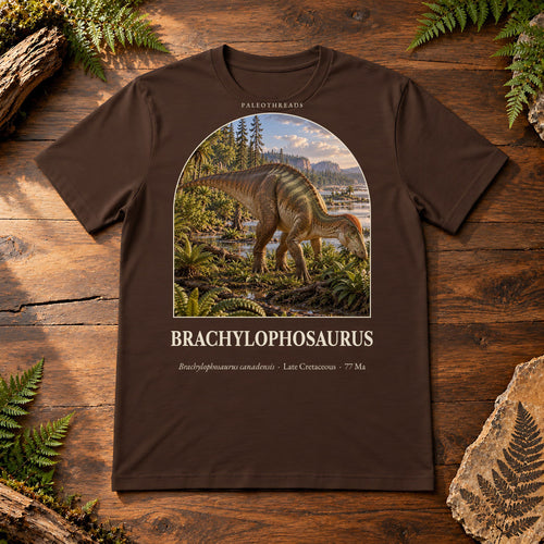 Brachylophosaurus t-shirt flat lay – brown PaleoThreads paleo art tee on a walnut field desk with ferns