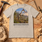 Quetzalcoatlus t-shirt flat lay – heather dust PaleoThreads paleo art tee on sandstone with a rock hammer