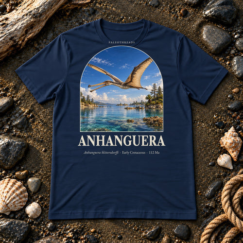 Anhanguera t-shirt flat lay – navy PaleoThreads paleo art tee on a fossil beach with driftwood