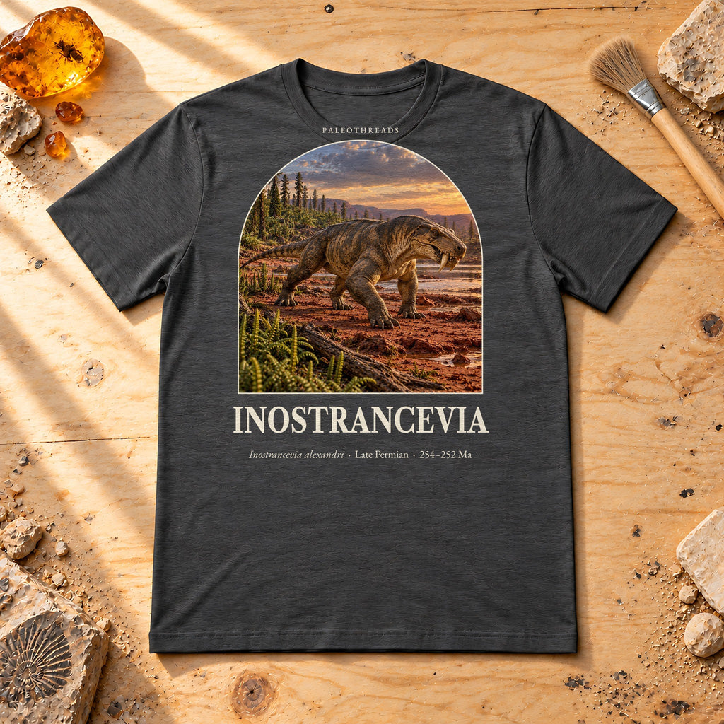 Inostrancevia t-shirt flat lay – dark grey heather PaleoThreads paleo art tee on a fossil prep bench with amber