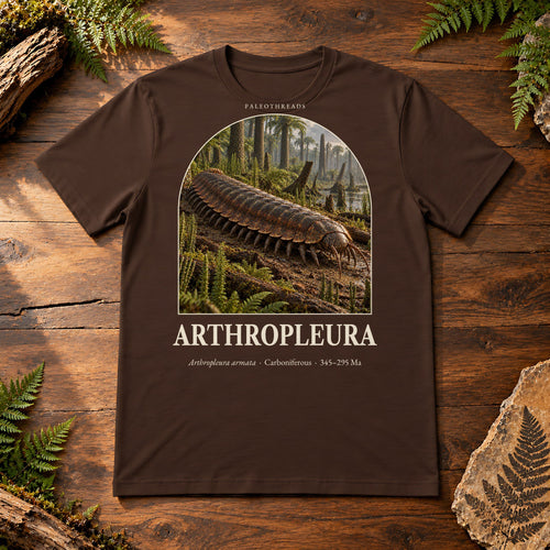 Arthropleura t-shirt flat lay – brown PaleoThreads paleo art tee on a walnut field desk with ferns