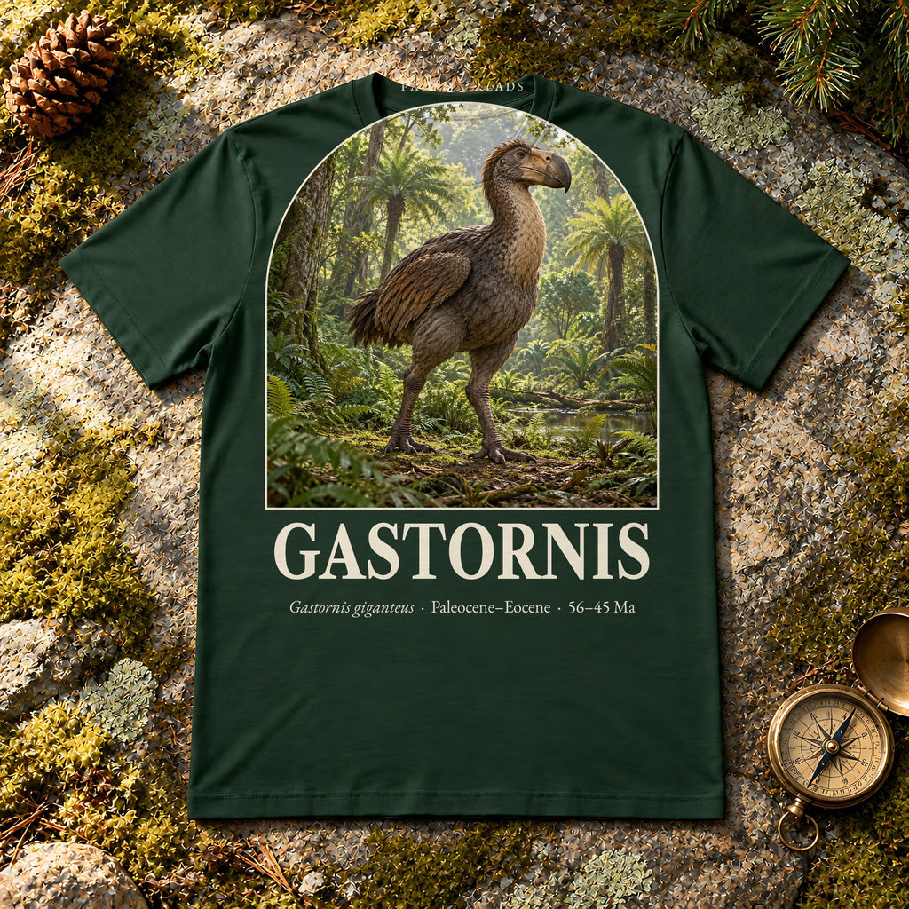 Gastornis t-shirt flat lay – forest PaleoThreads paleo art tee on mossy rock with a brass compass
